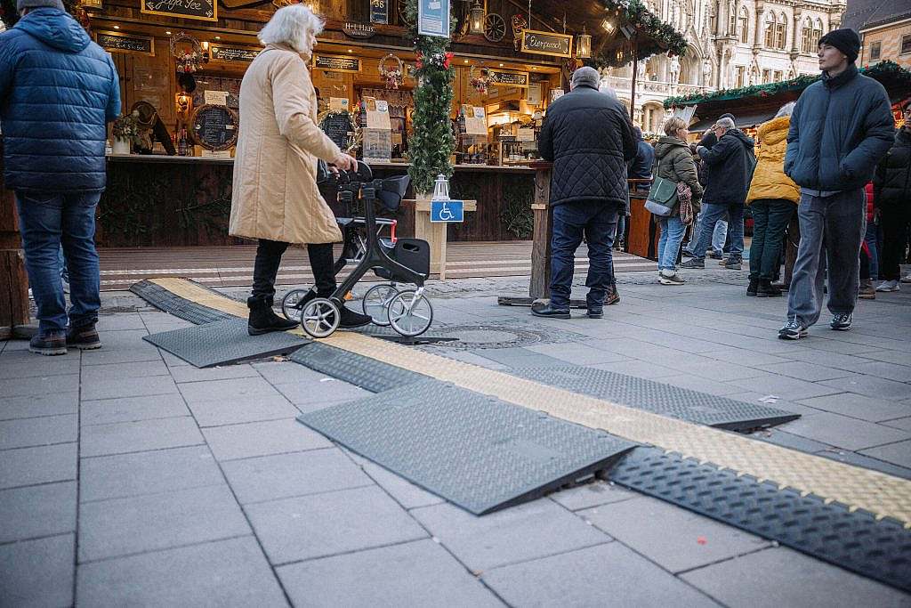 Elderly woman pushes walker over cable duct