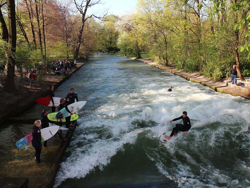 Several people with surfboards on the water