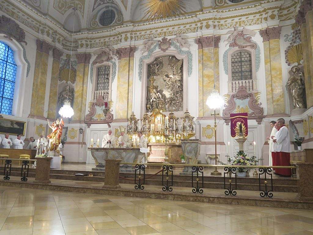An altar with candles, and three priests standing in front of it
