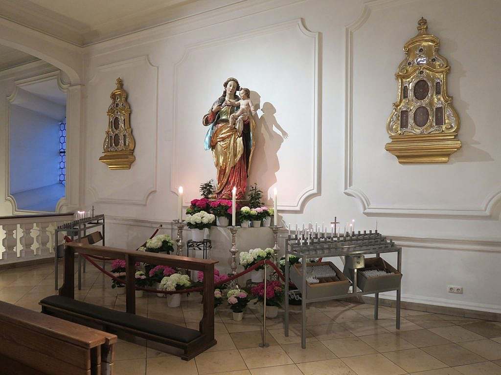 Altar mit Blumen, Kerzen und Marienfigur