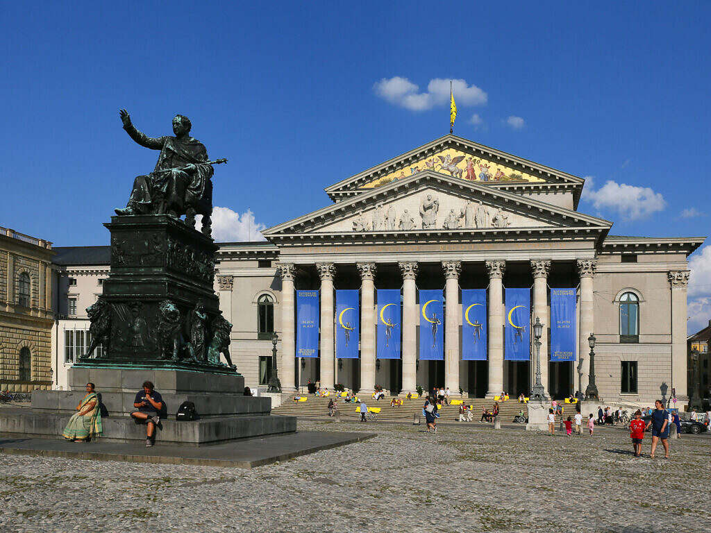 Many people and statue in front of the opera house