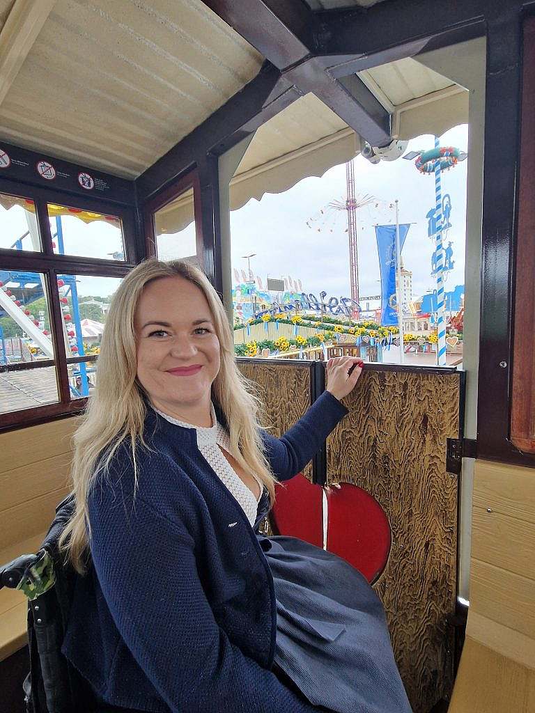 Frau im Rollstuhl in Riesenrad-Gondel