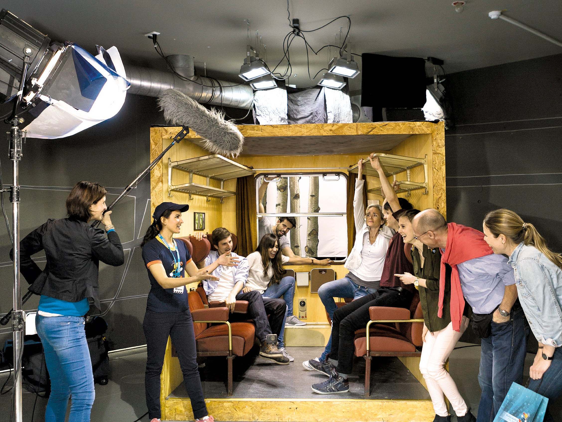 Several people in a train compartment recreated for filming during filming
