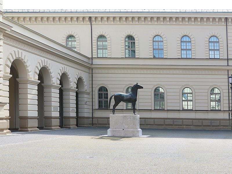 Building with arcade, horse statue in front