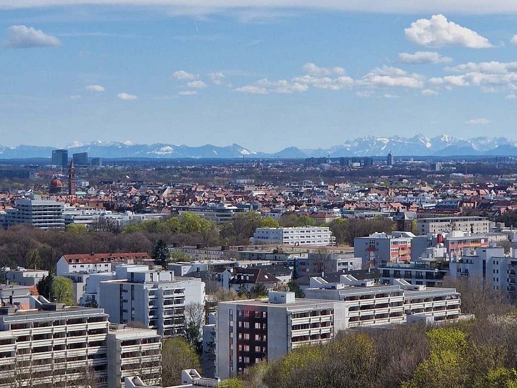 Hoch über den Dächern Münchens mit Alpenpanorama im Hintergrund